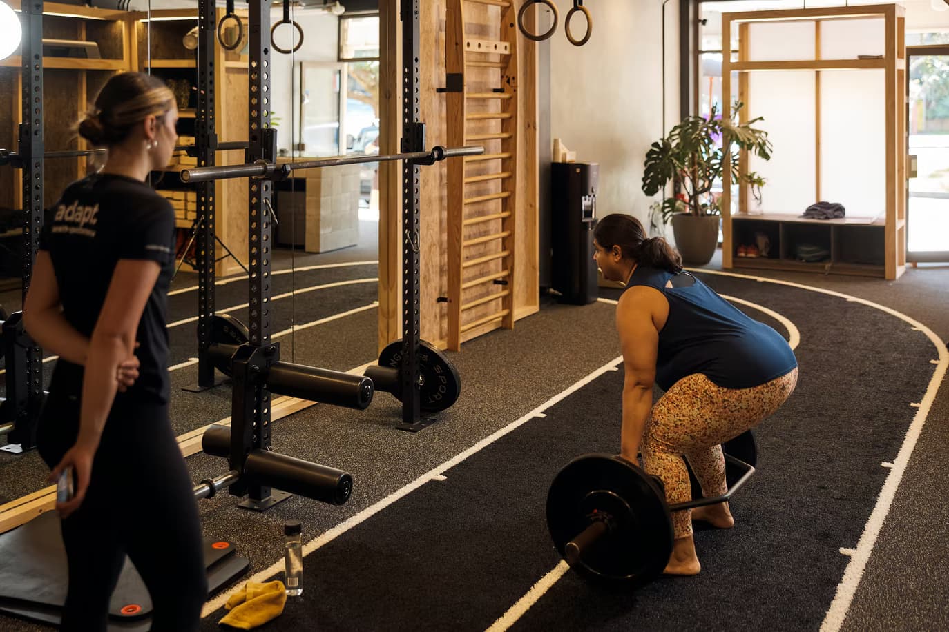 Personal trainer guiding a client through squats at AHP North Sydney